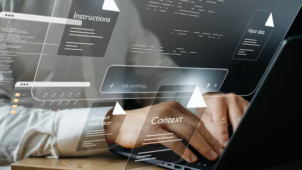 Close-up of person's hands on computer keyboard with graphics indicating they are using AI prompts.