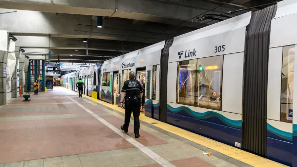 Security officer walks next to Sound Transit train in underground station in Seattle, Washington.