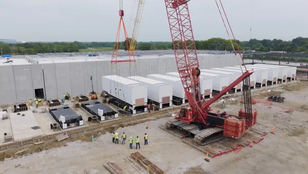 Data center complex under construction in field surrounded by green forest in Texas.