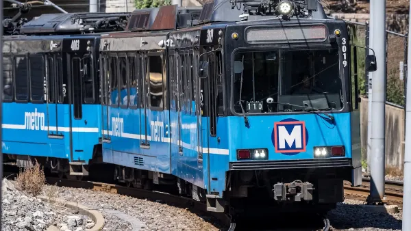 A blue Metrolink train with two cars drives toward the camera. 