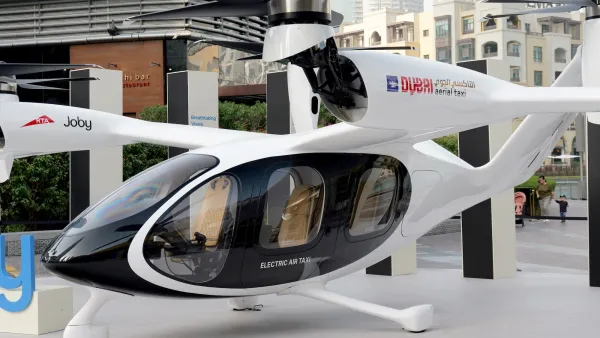 A white air taxi shaped like a helicopter on display in Dubai.