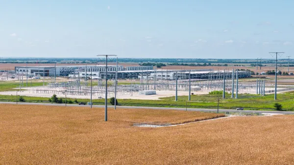 A power grid in Texas. There is brown dirt in the foreground, and trees in the background.