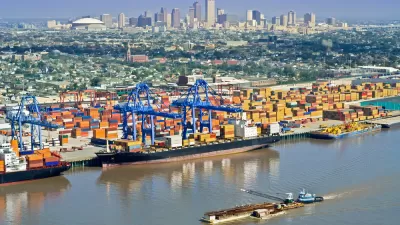 Aerial view of New Orleans port with cranes and barges and skyline in background