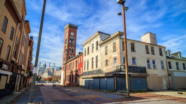 Historic abandoned brick buildings in Baltimore with boarded-up windows.