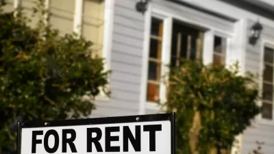 For rent sign with blurry house in background