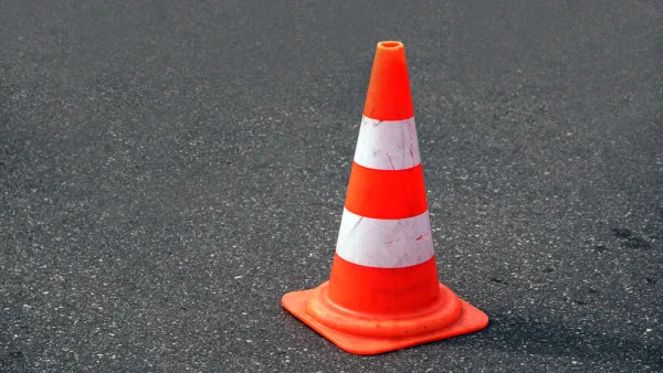 Orange traffic cone on black asphalt