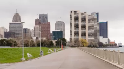 Waterfront walkway with benches and Detroit skyline in the background