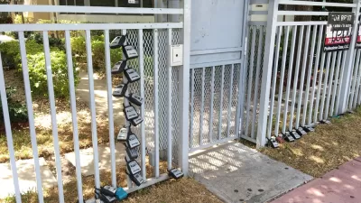 Gate in front of Miami Beach apartment building with many lock boxes for short-term renter access