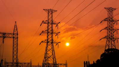 Power lines and towers at a substation against a red sunset backdrop
