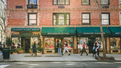 Greenwich Village street with red brick buildings with green awnings and businesses on first floor