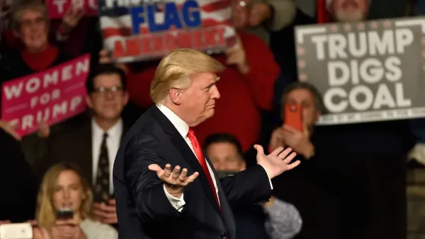 Trump at rally in Hershey, PA with person holding "Trump Digs Coal" sign visible in background.