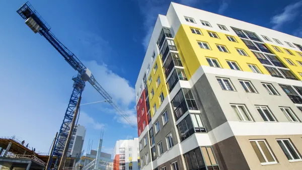 Multistory building under construction with crane visible on the left.