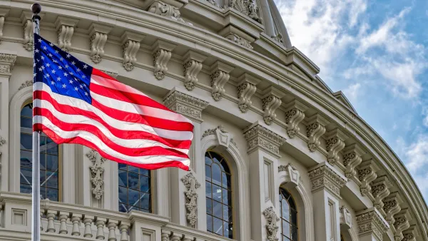 Close-up on Capitol Dome with American flag blowing in the wind in front of it.