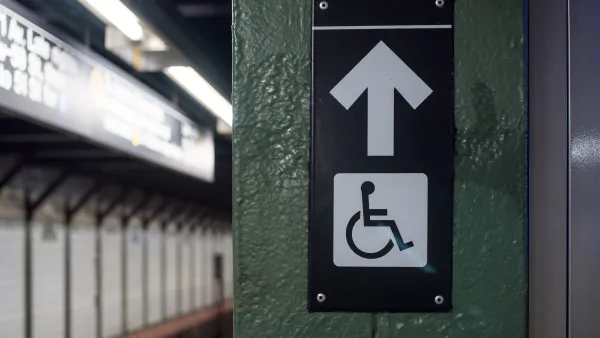 Accessible elevator sign with arrow on a New York City subway platform