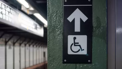 Accessible elevator sign with arrow on a New York City subway platform