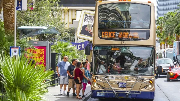 Gold double decker bus picking up passengers on the Las Vegas strip.