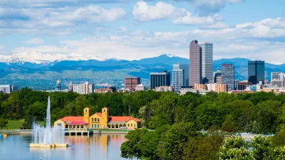 Denver, Colorado skyline with park and lake in foreground and mountains in background