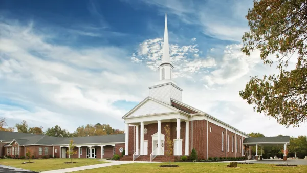 Traditional small brick church with tall white steeple in Virginia.