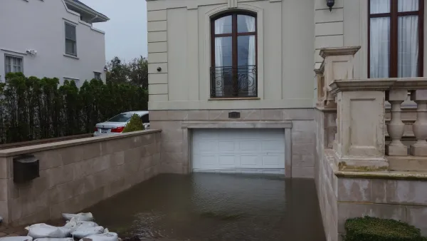 Basement-level garage door with floodwater halfway up on home in Far Rockaway, New York after hurricane.