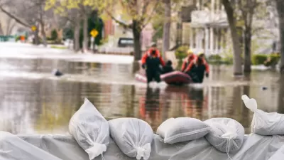 Sandbags in a flood with flooded buildings in background