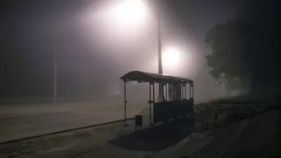 Bus shelter from behind at night with mist and streetlights