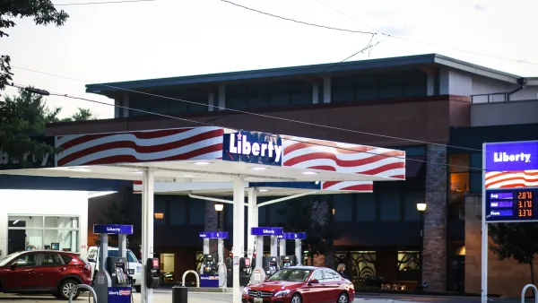 Gas station named Liberty painted with red and white US flag stripes with red cars at gas pump in Bethesda, Maryland.