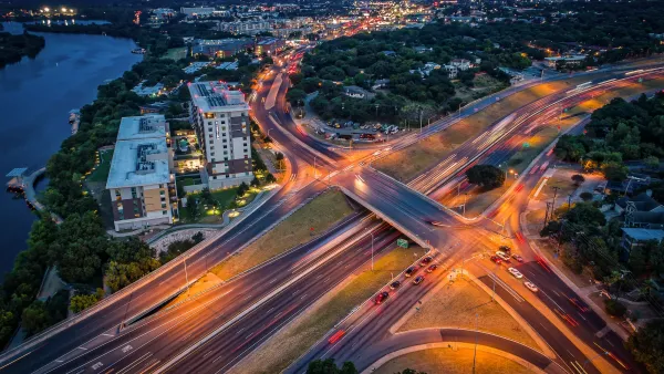 Interstate 35 over Riverside Drive at dusk in Austin, Texas with downtown visible in background.