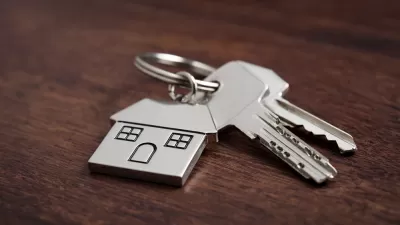 House key with house-shaped keychain on table