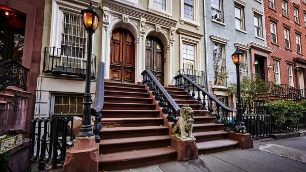 Close-up on stoop in row of elegant New York City brownstone homes.
