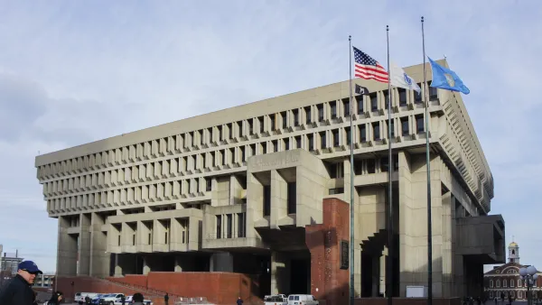 Brutalist Boston City Hall building with parking and people walking in front.