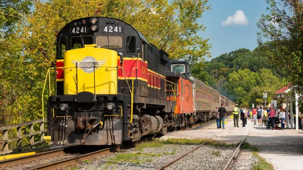 Yellow, red, and black Cuyahoga Valley Scenic Railroad locomotive at station.