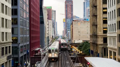 Two Chicago elevated trains with city buildings in background