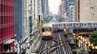 Chicago elevated train over busy city street surrounded by high-rise buildings