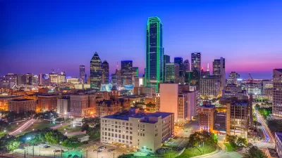 View of downtown Dallas skyline at night with tall tower lined with green lights