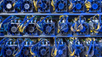 Wall of computer servers with blue and yellow cables for cryptocurrency mining
