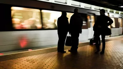 Three commuters on train platform sillhouetted against moving train
