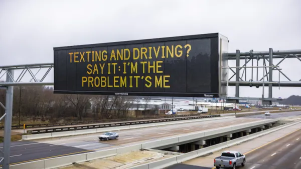 Digital highway sign above six-lane highway that says, "Texting and Driving? Say It: I'm the Problem It's Me." 