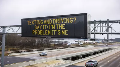 Digital highway sign above six-lane highway that says, "Texting and Driving? Say It: I'm the Problem It's Me."