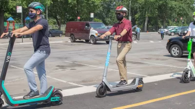 Three people wearing helmets riding electric scooters in New York City